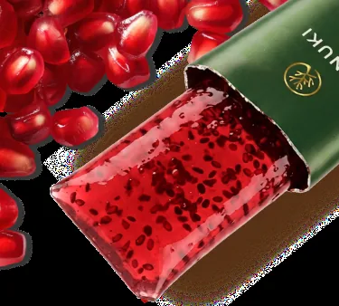 Close-up of the Hinuki jelly showing dark chia seeds suspended in the red pomegranate gel, next to loose pomegranate seeds.